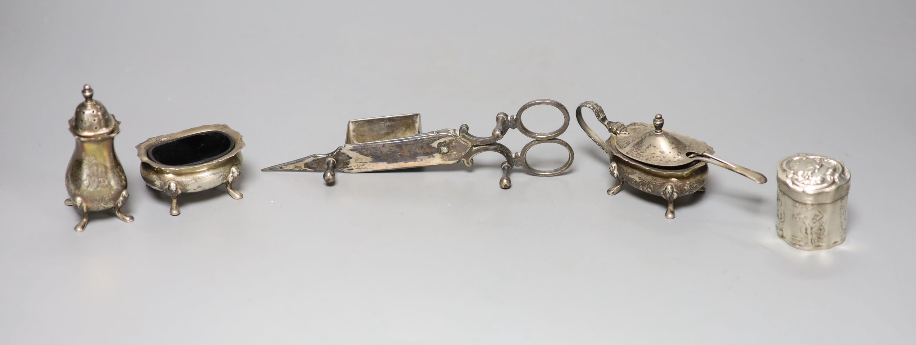 A silver three piece condiment set, a Dutch white metal pill box and a pair of plated candle snuffers.